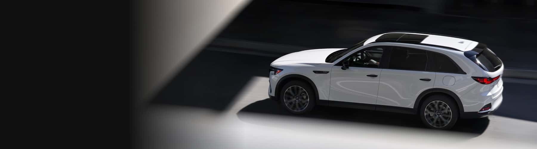 White Mazda CX-70 driving down a road