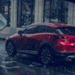 red mazda suv driving in the rain