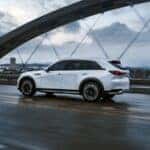 white 2026 cx-90 phev driving across a bridge