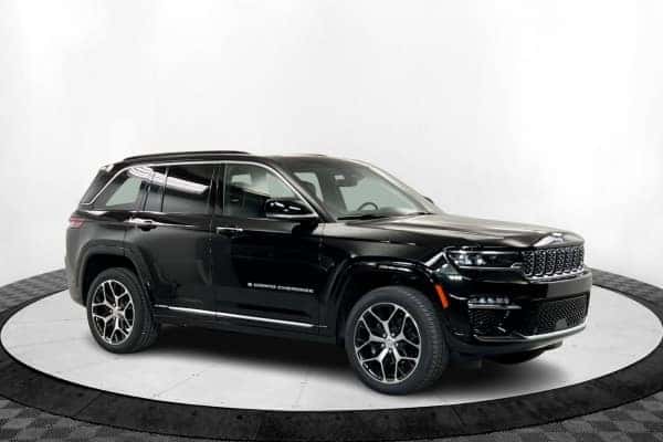 A side view of a black Jeep Grand Cherokee standing at the showroom in St. George, UT