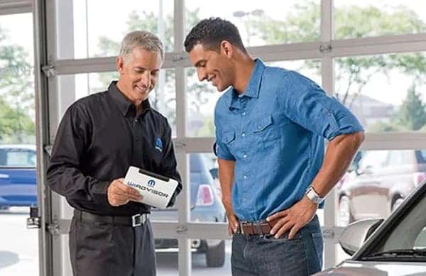 A reception staff member is highlighting the vehicle service and parts tips in St. George, UT