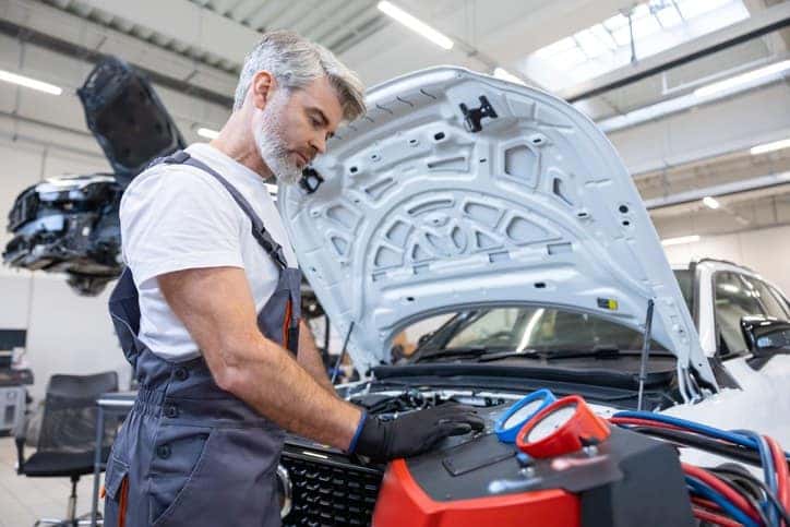 A technician is performing the car AC maintenance services in St. George, UT