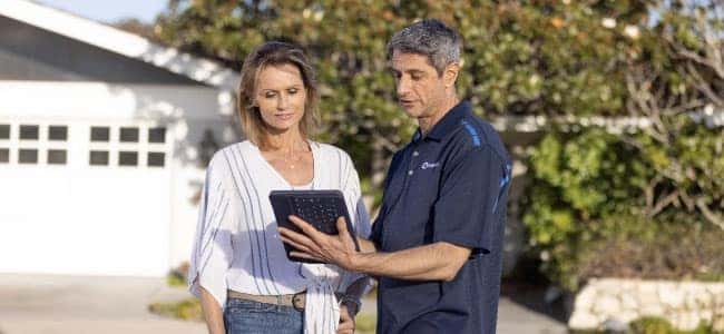 man showing woman tablet